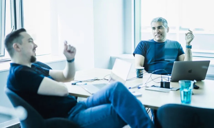 Two colleagues talking across a desk